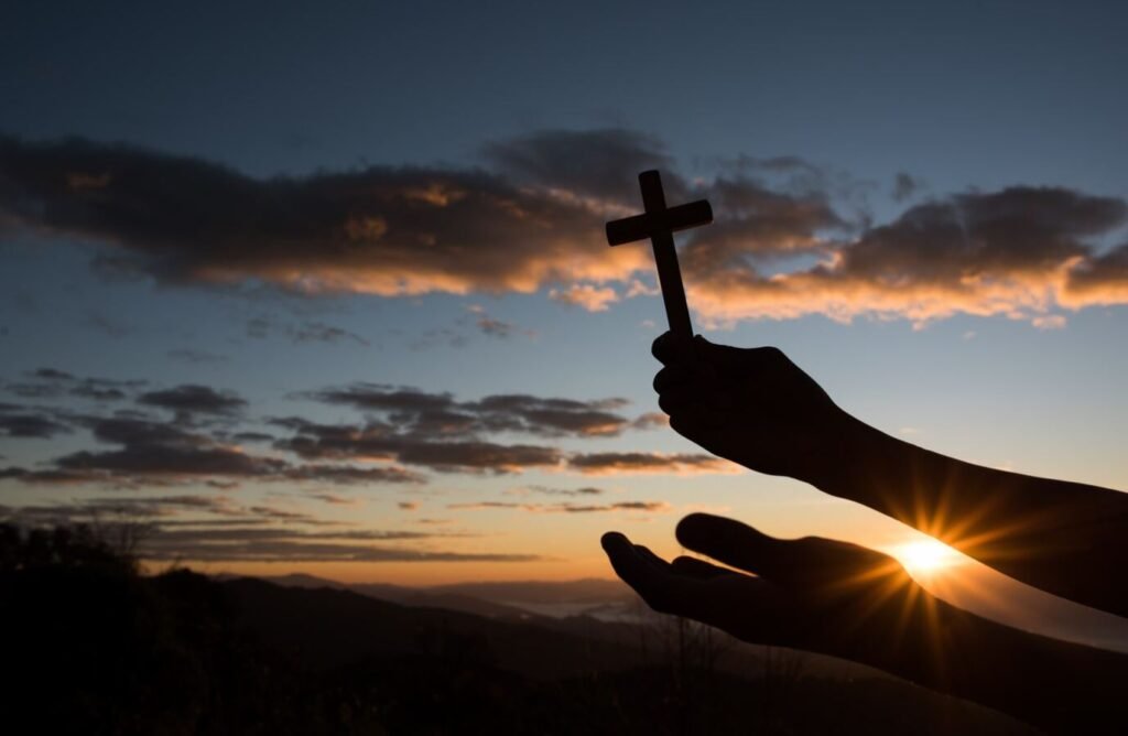 paisaje religioso cristiano católico en donde se muestra una cruz en el amanecer 