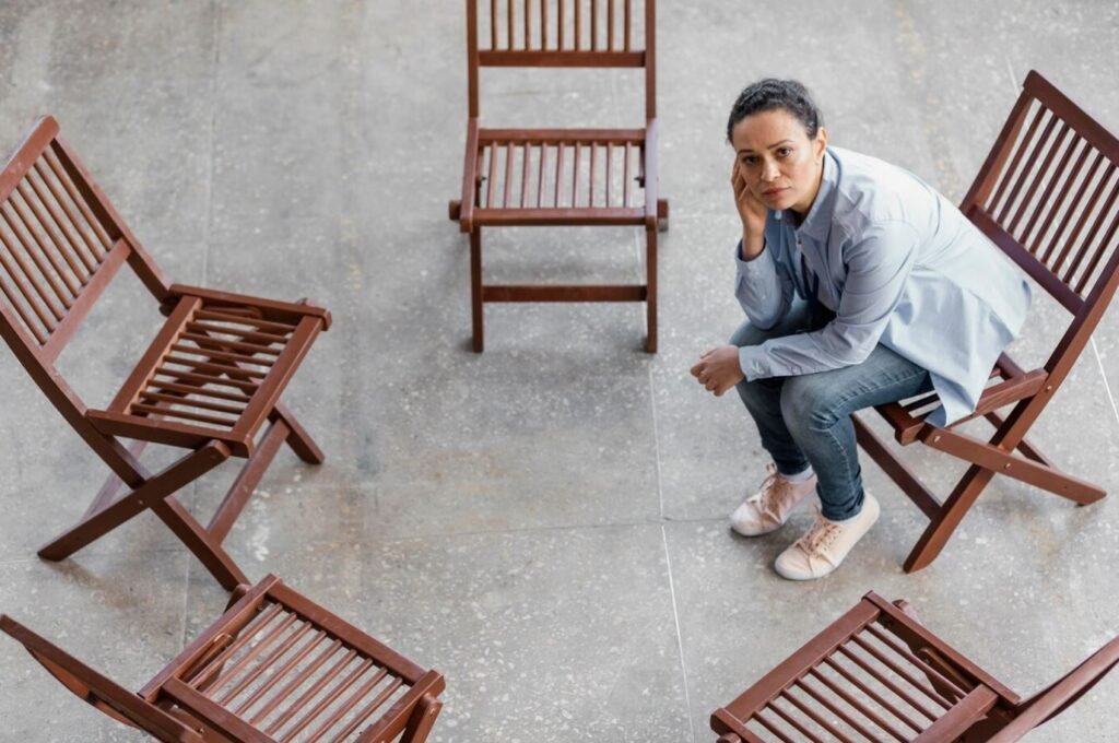 ansiedad social un par de sillas vacías donde solo hay una chica sola triste  