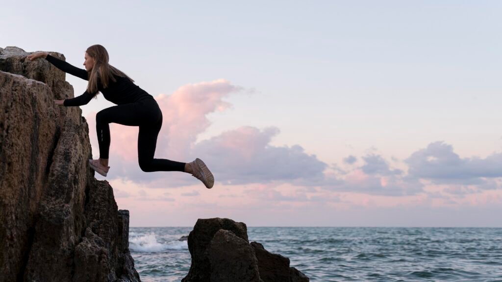 mujer escalando la costa desde una perspectiva lateral