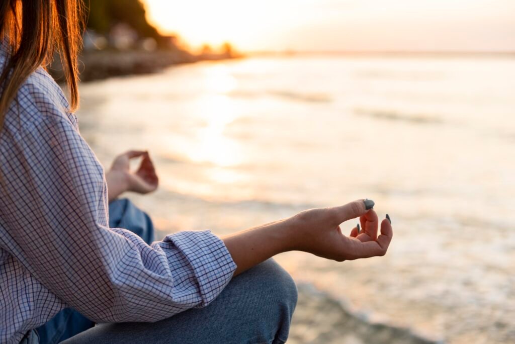 Mujer meditando en la playa con espacio de copia a escala
