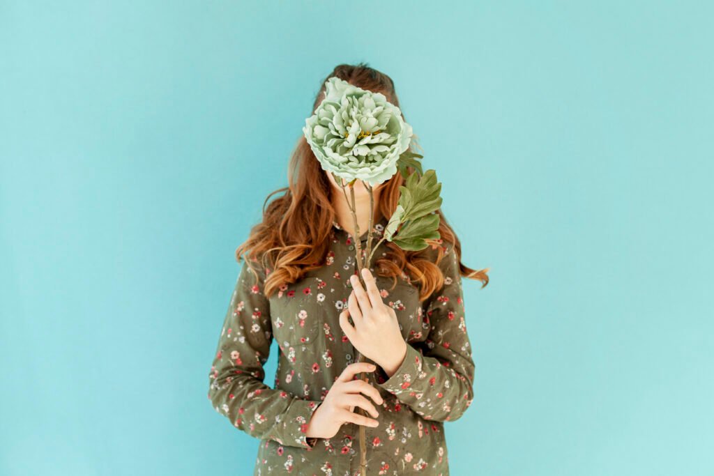 Mujer cubriéndose la cara con flores frescas