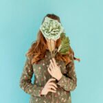 Mujer cubriéndose la cara con flores frescas