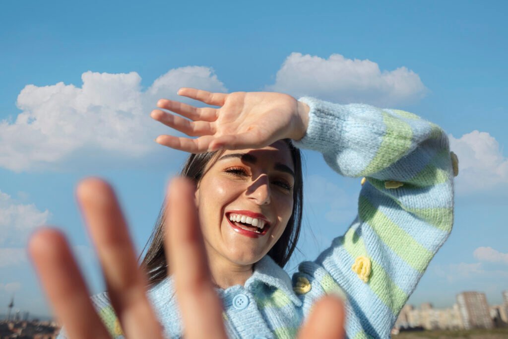 Mujer joven protegiéndose los ojos del sol en un campo al aire libre
